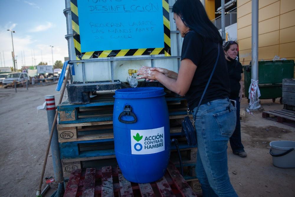 mujer desinfectándose las manos - punto de lavado - Acción contra el Hambre - DANA Valencia Emergencia